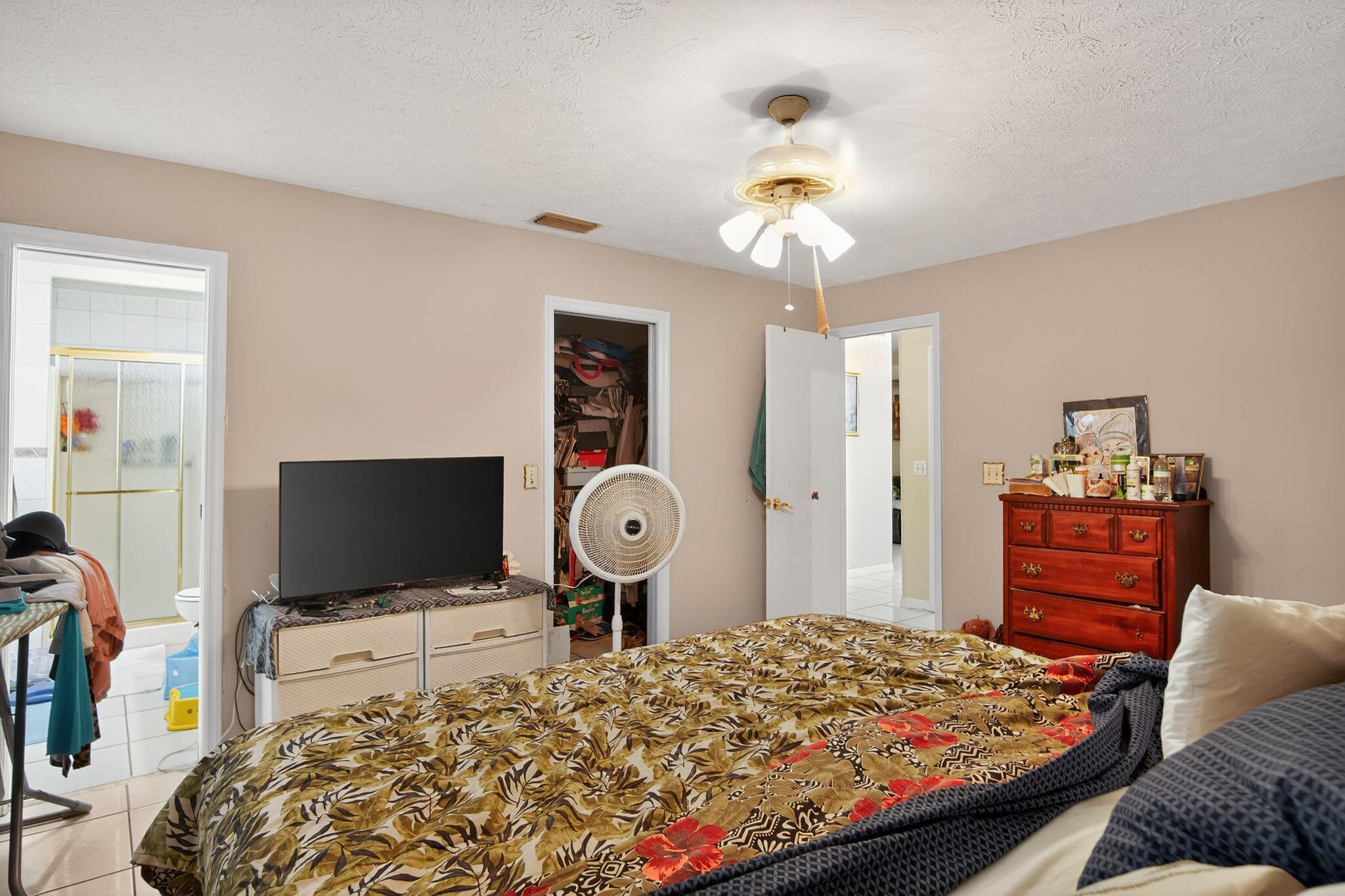 3053 Southeast Wake Road Port St. Lucie, FL 34984 - Photo 4 of 28 a bedroom with a bed and a flat screen tv