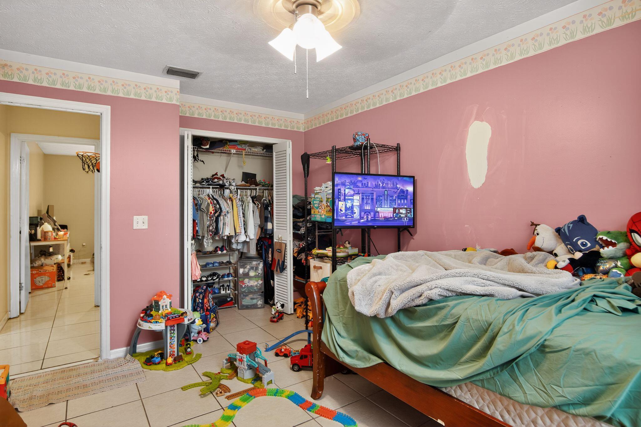 3053 Southeast Wake Road Port St. Lucie, FL 34984 - Photo 5 of 28 a bedroom with a bed and a chandelier