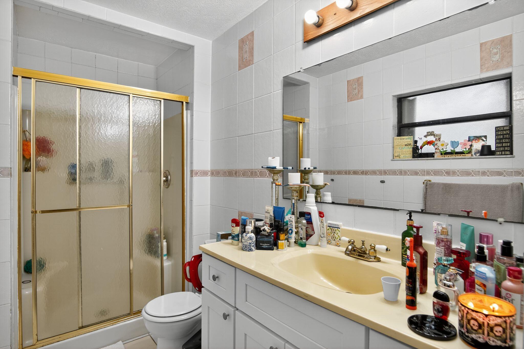 3053 Southeast Wake Road Port St. Lucie, FL 34984 - Photo 8 of 28 a bathroom with a sink vanity mirror and toilet