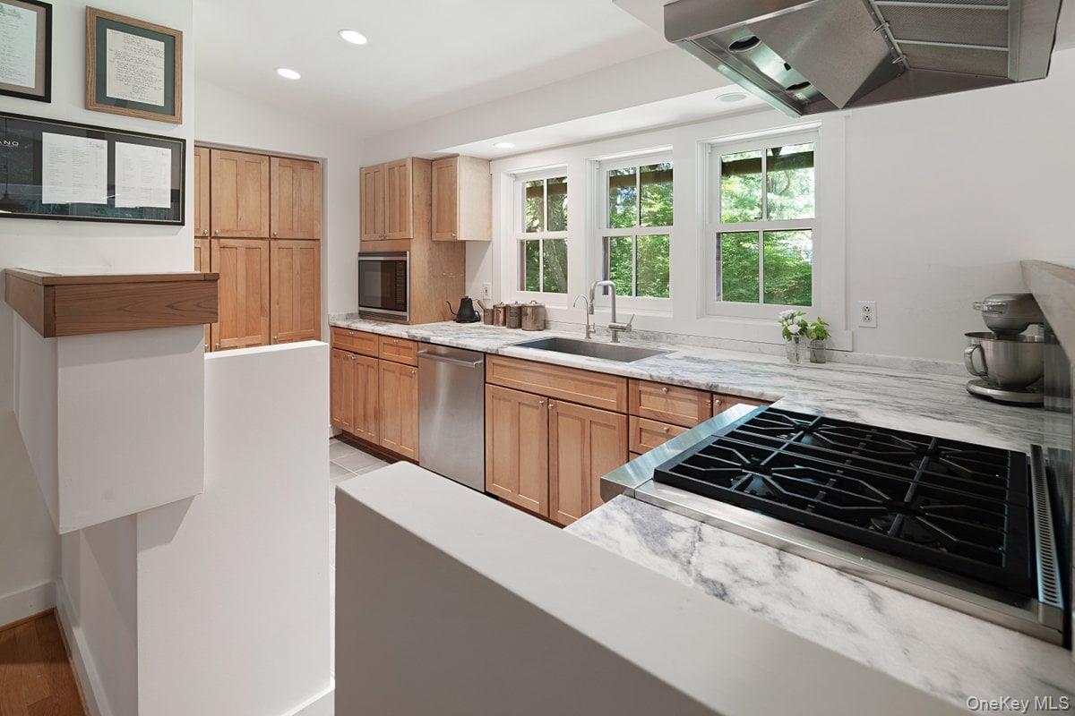 1821 Spring Valley Road Ossining, NY 10562 - Photo 21 of 48 View into the chef's kitchen featuring a wall of windows above the sink, custom wood cabinets, stainless steel appliances, and quartz countertops.