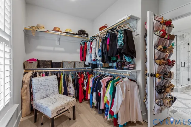 a view of walk in closet with clothes