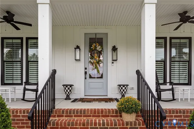 a view of a house with a big yard potted plants and a large tree