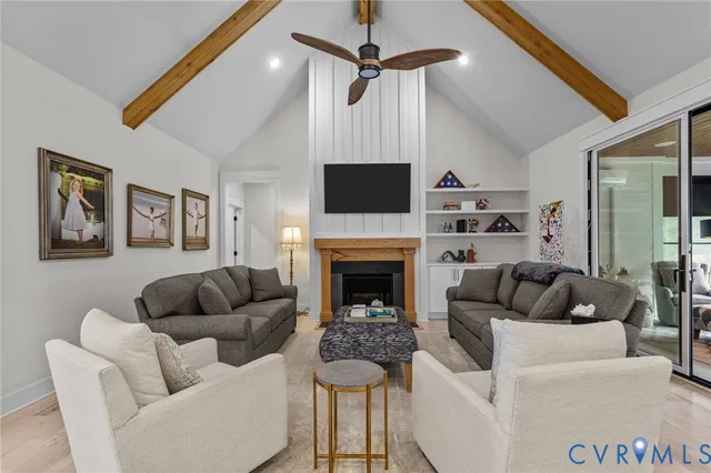 a large kitchen with a table chairs stainless steel appliances and wooden floor