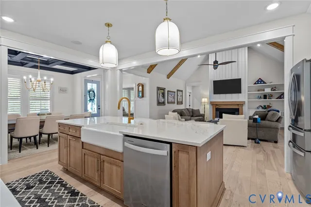 a large kitchen with a table chairs stainless steel appliances and wooden floor
