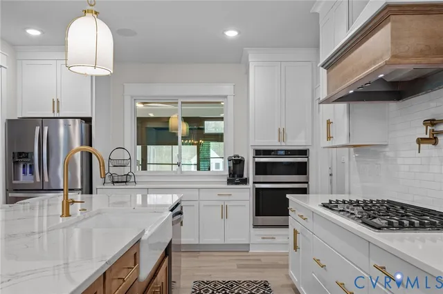 a kitchen with stainless steel appliances granite countertop a sink a stove and a refrigerator