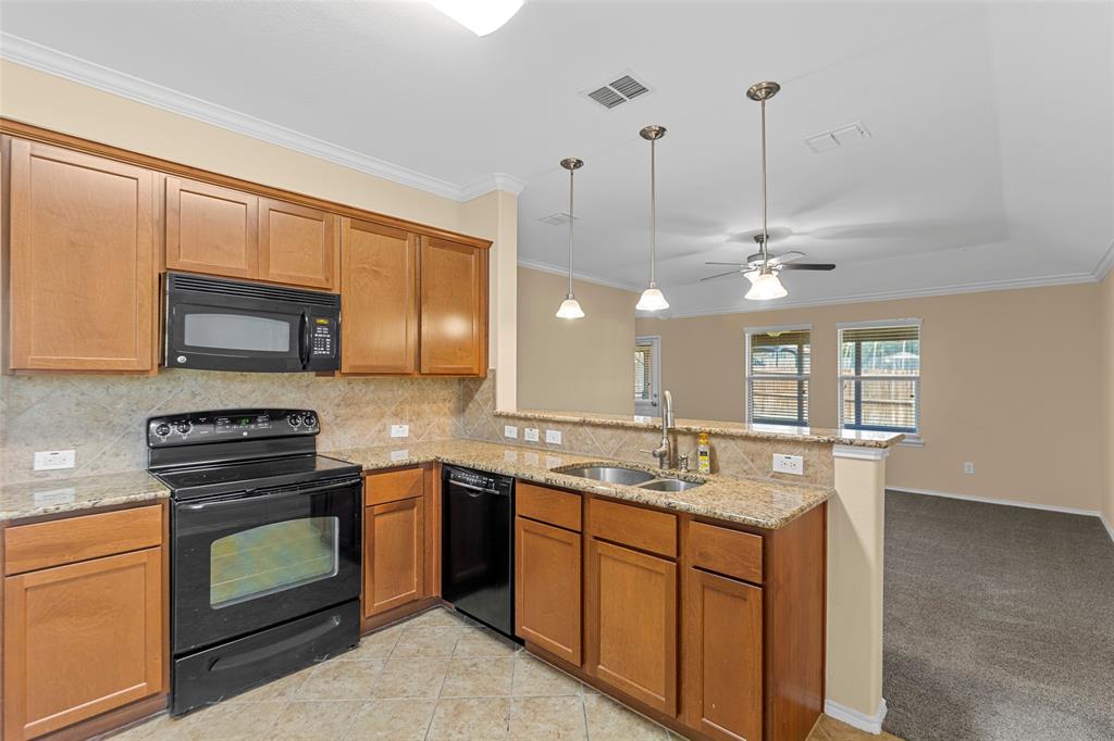 716 Harrison Lane Lavon, TX 75166 - Photo 30 of 40 a kitchen with stainless steel appliances granite countertop a sink a stove and a microwave oven