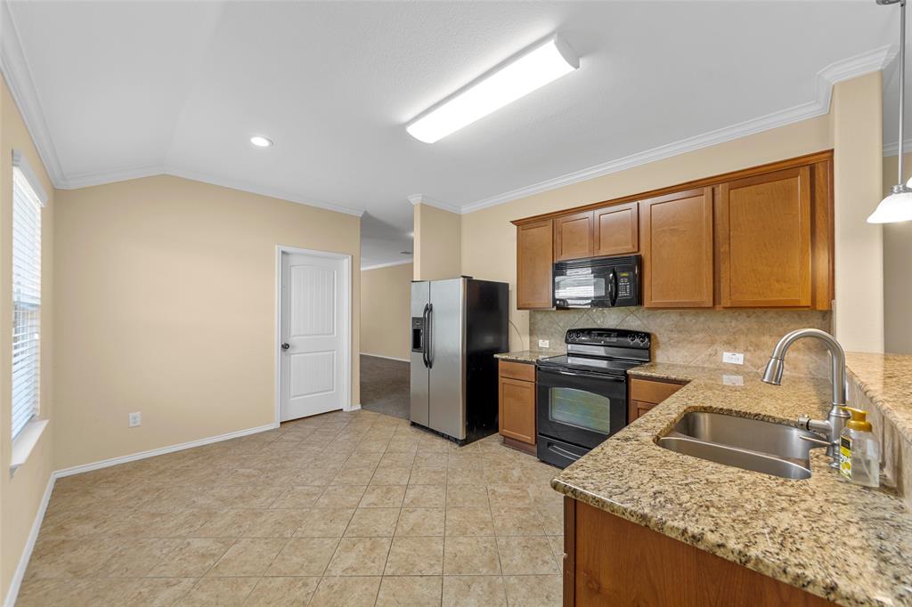 716 Harrison Lane Lavon, TX 75166 - Photo 31 of 40 a kitchen with stainless steel appliances granite countertop a sink stove and refrigerator