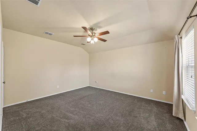 an empty room with a window and a ceiling fan
