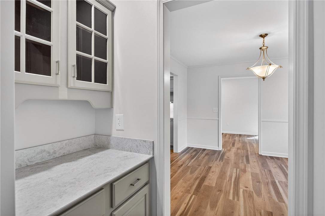 9 Lookout Lane Salem, SC 29676 - Photo 7 of 46 A hallway connects living areas, showcasing wood floors and an elegant chandelier.