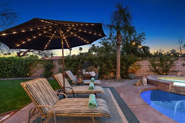 a view of a patio with a table chairs and a fire pit