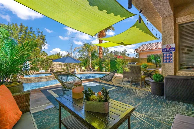 a view of a house with swimming pool and sitting area
