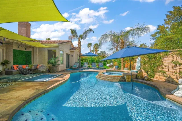 a view of a swimming pool with sitting area and furniture