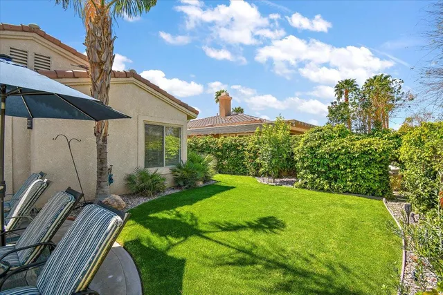 a view of a patio with table and chairs potted plants and large tree