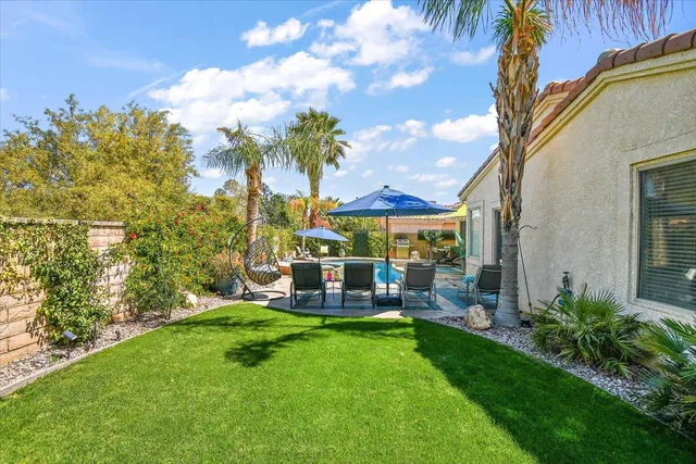 a view of a patio with table and chairs potted plants and palm tree