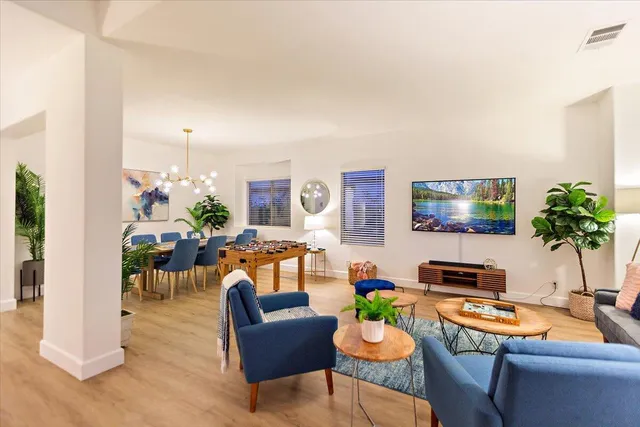 a living room with furniture kitchen view and a large window
