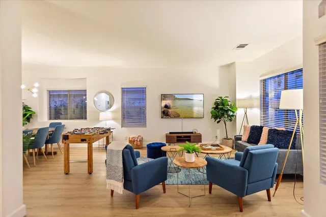 a living room with furniture kitchen view and a window