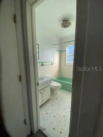 a bathroom with a granite countertop toilet and a sink