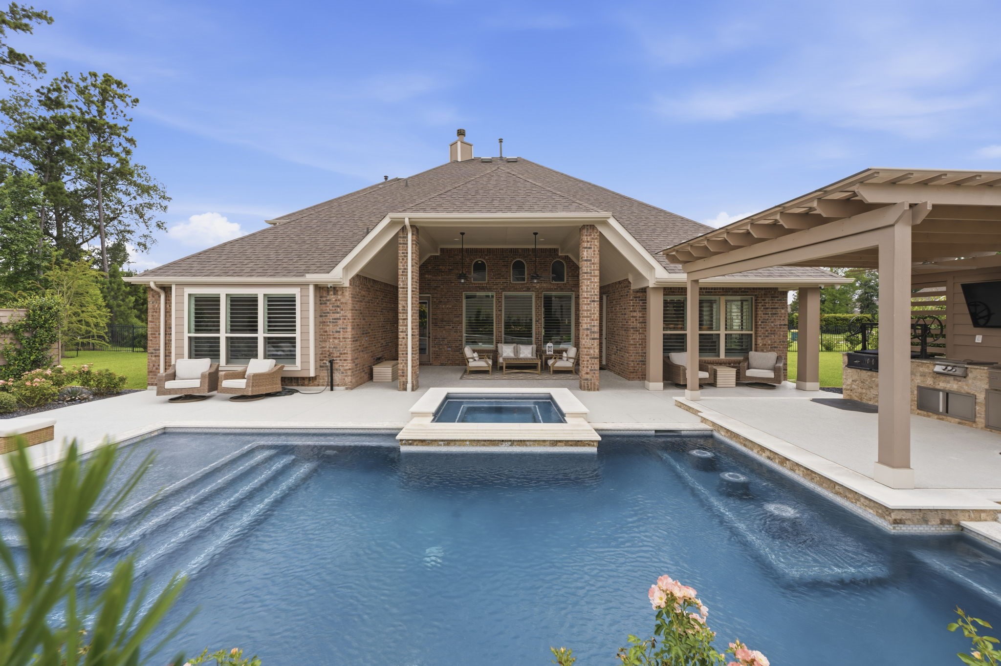 14012 Beartooth Bend Trail Conroe, TX 77384 - Photo 4 of 50 Before stepping inside, take a moment to enjoy the resort-style outdoor living spaces designed in 2023 for year-round entertaining and relaxation. The covered porch offers a cozy retreat while the outdoor kitchen is fully equipped with several grilling areas and an imported Italian pizza oven - perfect for hosting family and friends. Completing the backyard oasis is a newer pool and spa, creating the ideal setting to unwind in style and comfort.