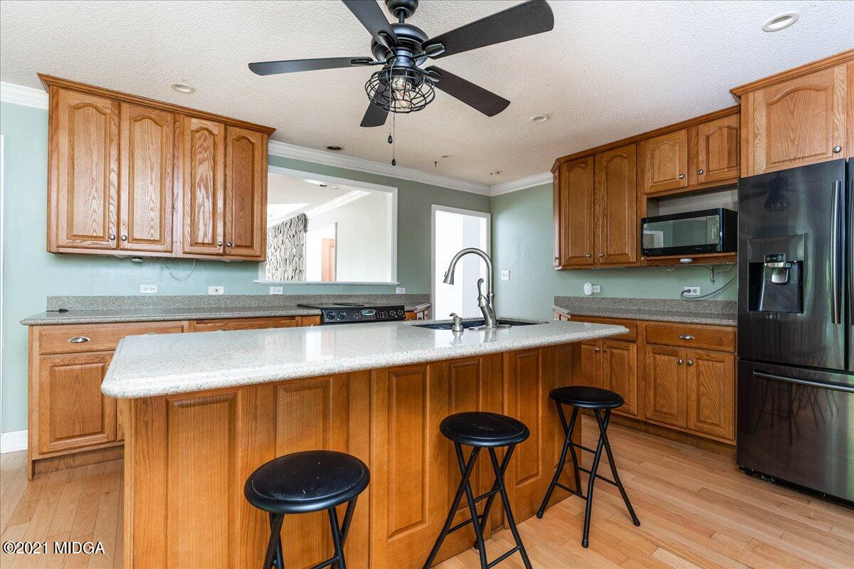 455 Lite-N-Tie Road Gray, GA 31032 - Photo 14 of 47 a kitchen with stainless steel appliances a sink a stove a refrigerator cabinets and dining table