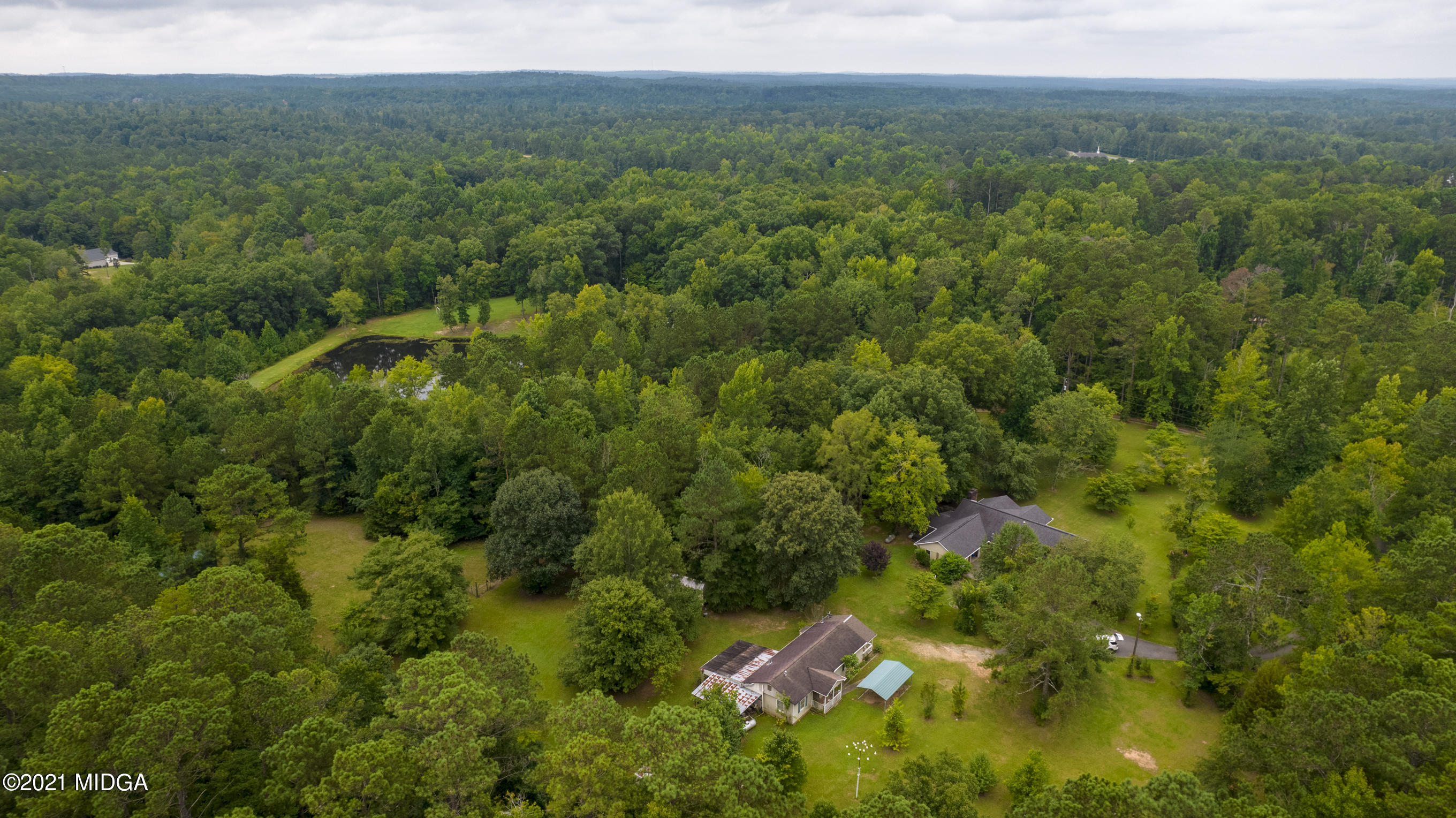 455 Lite-N-Tie Road Gray, GA 31032 - Photo 43 of 47 a view of a lush green forest with trees and some houses