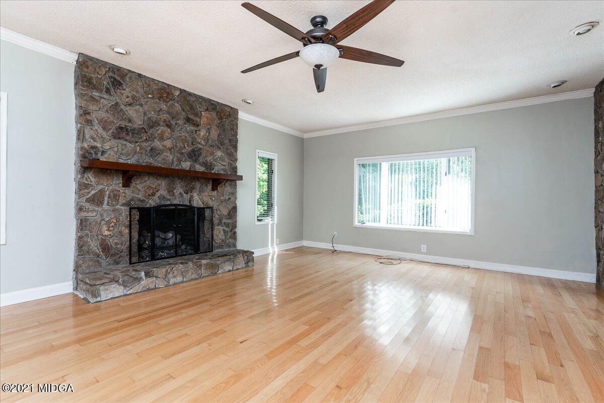 455 Lite-N-Tie Road Gray, GA 31032 - Photo 10 of 47 a view of an empty room with wooden floor a fireplace and a window