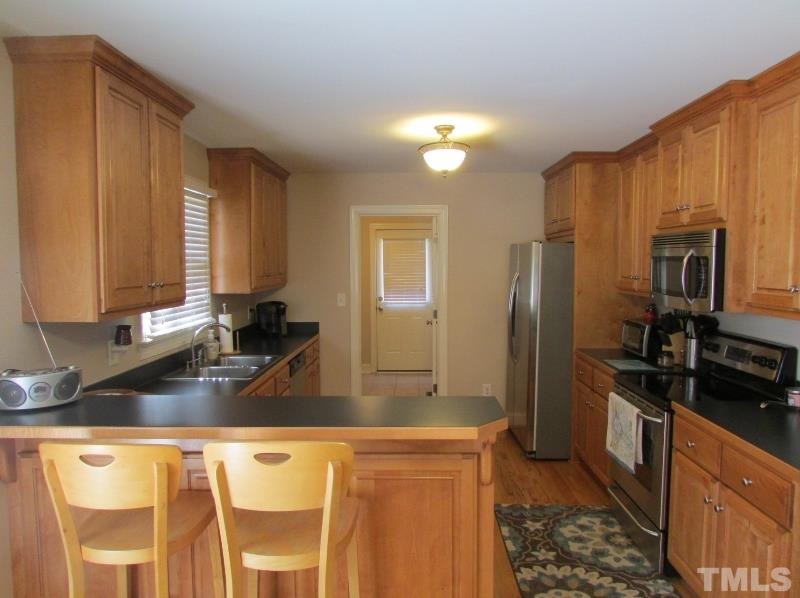 216 Piney Forest Road Roxboro, NC 27574 - Photo 6 of 23 Kitchen and dining area are open to each other. Utility room is located behind the kitchen.