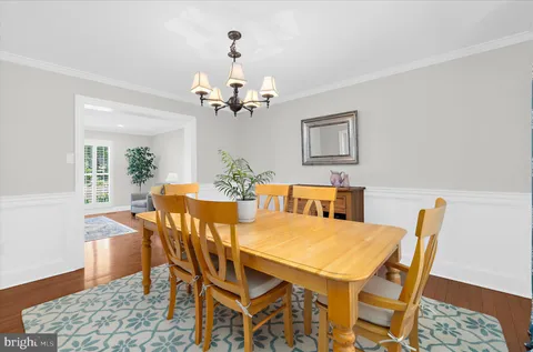 a kitchen with granite countertop a stove top oven a sink dishwasher a dining table and chairs with wooden floor