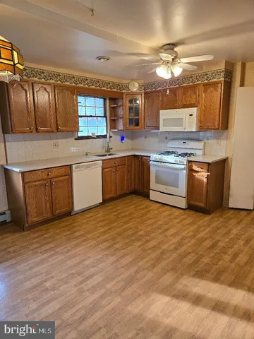 a large kitchen with stainless steel appliances granite countertop a sink dishwasher stove and oven