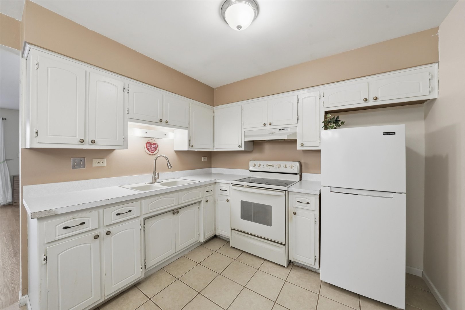 6525 West 64th Place, Unit 1W Chicago, IL 60638 - Photo 6 of 14 a kitchen with white cabinets and white appliances