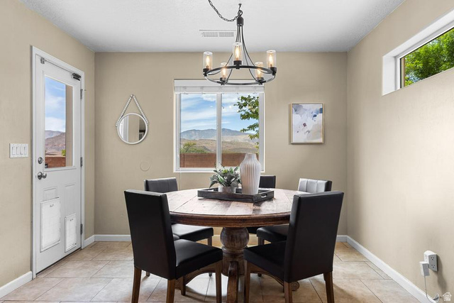 225 Falcon Court Ivins, UT 84738 - Photo 9 of 47 Dining room featuring a mountain view, light tile patterned floors, and a chandelier