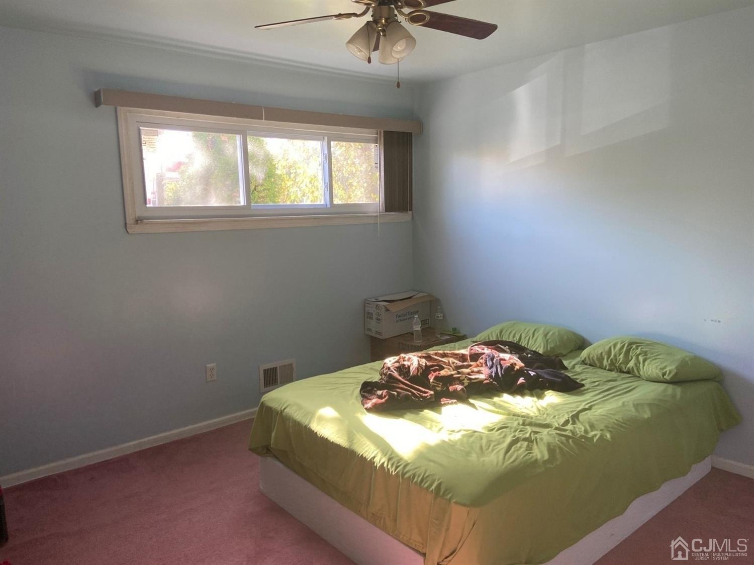 1602 Oak Tree Road Iselin, NJ 08830 - Photo 8 of 13 a bedroom with a bed and a chandelier