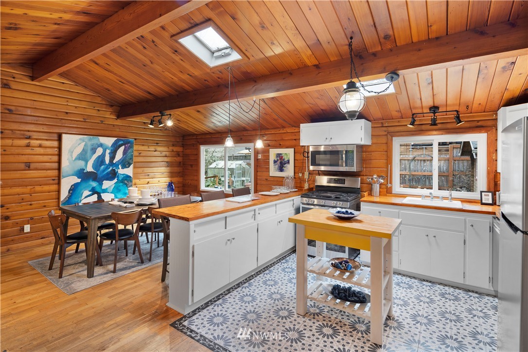 14255 183rd Avenue Southeast Renton, WA 98059 - Photo 11 of 32 a open kitchen with stainless steel appliances granite countertop a stove a sink dishwasher and cabinets with wooden floor