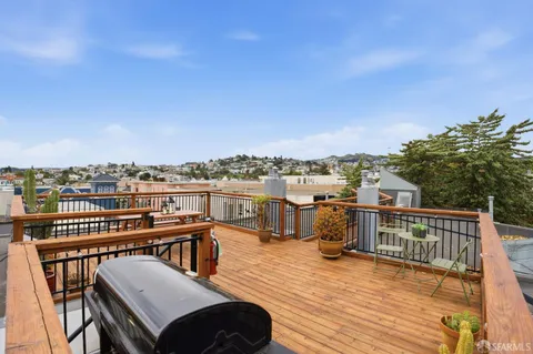a view of a balcony with wooden floor and city view