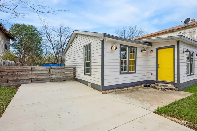 a view of backyard with large trees and a wooden fence
