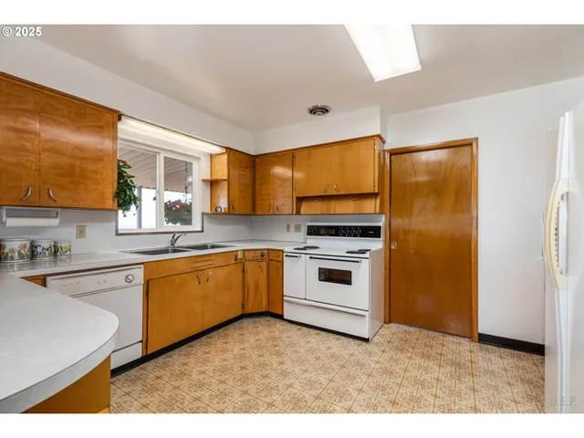 a kitchen with granite countertop white cabinets and white appliances