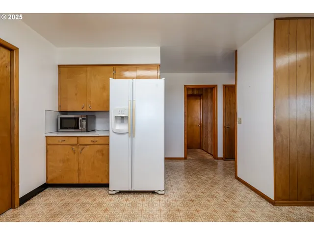 a view of kitchen with utility room and refrigerator