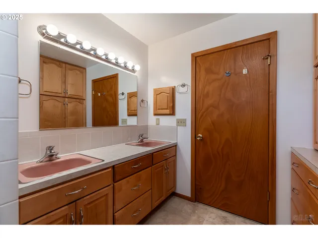 a bathroom with a double vanity sink a mirror and shower