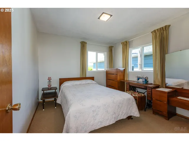 a bedroom with a bed a table and chair