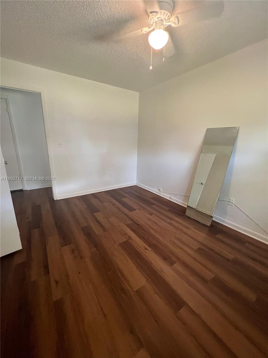 8935 Southwest 104th Place Ocala, FL 34481 - Photo 15 of 21 an empty room with wooden floor and fan