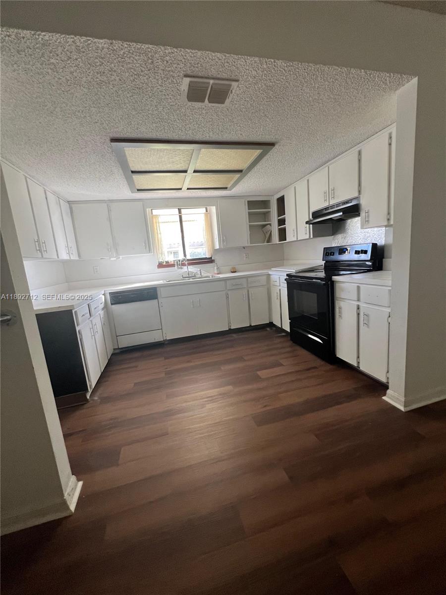 8935 Southwest 104th Place Ocala, FL 34481 - Photo 4 of 21 a kitchen with granite countertop a stove top oven and cabinets