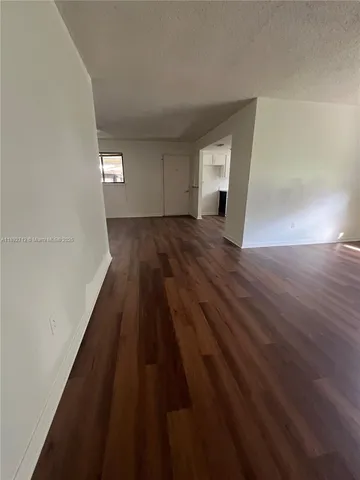 a view of a room with wooden floor and window