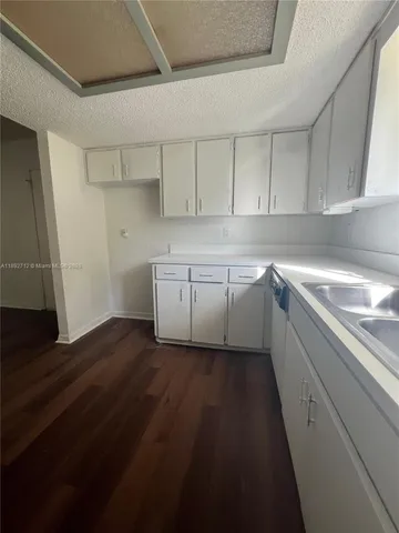 a kitchen with a sink window and cabinets