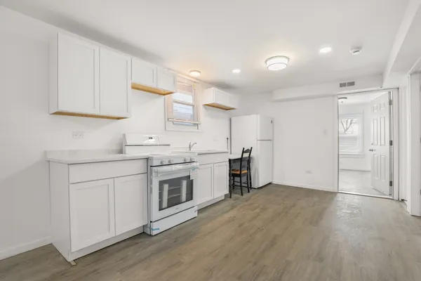 a kitchen with a sink cabinets and wooden floor