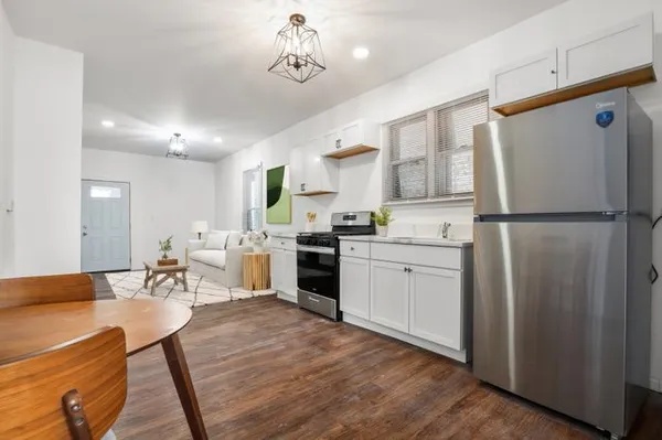 a kitchen with a refrigerator a microwave oven a sink and chairs