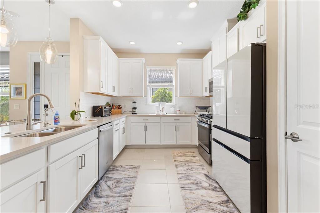 6236 Grandview Hill Court Bradenton, FL 34203 - Photo 3 of 16 a kitchen with white cabinets and white appliances