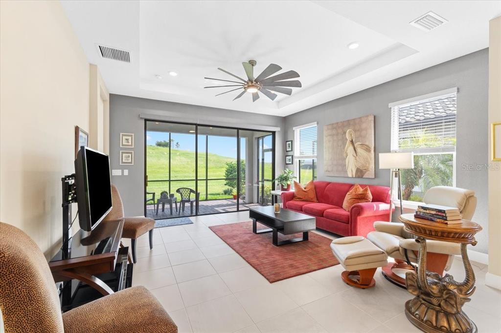 6236 Grandview Hill Court Bradenton, FL 34203 - Photo 6 of 16 a living room with furniture floor to ceiling window and a flat screen tv