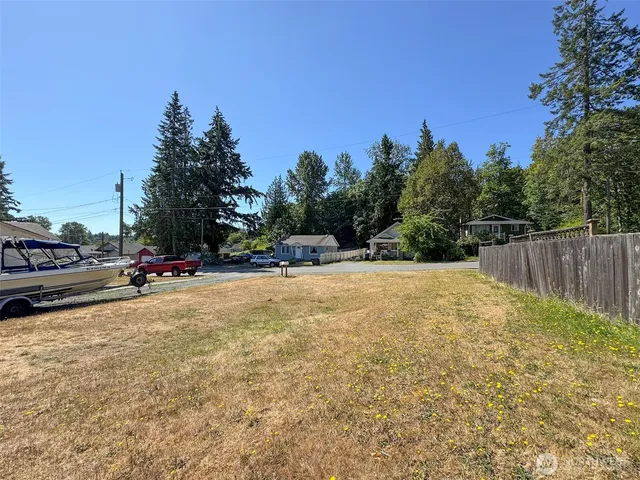 a backyard of a house with table and chairs a barbeque with wooden fence