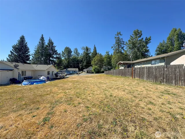 a backyard of a house with lots of green space and fountain