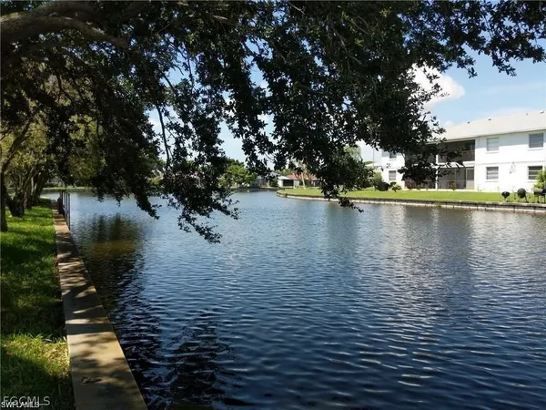a swimming pool with outdoor seating and lake view
