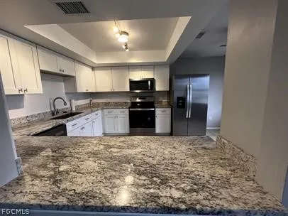 a kitchen with granite countertop a stove sink and cabinets